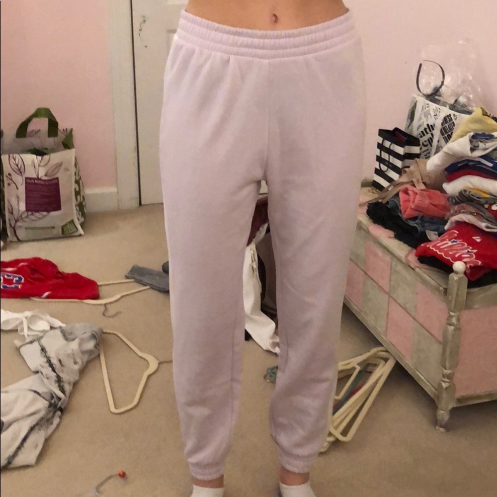 Purple sweatpants with white stripes on sides